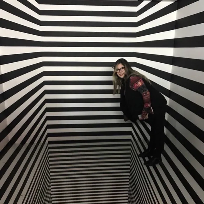 Júlia numa sala listrada em preto e branco